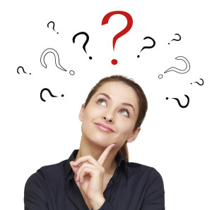 Thinking smiling woman with questions marks above looking up on red sign isolated on white background